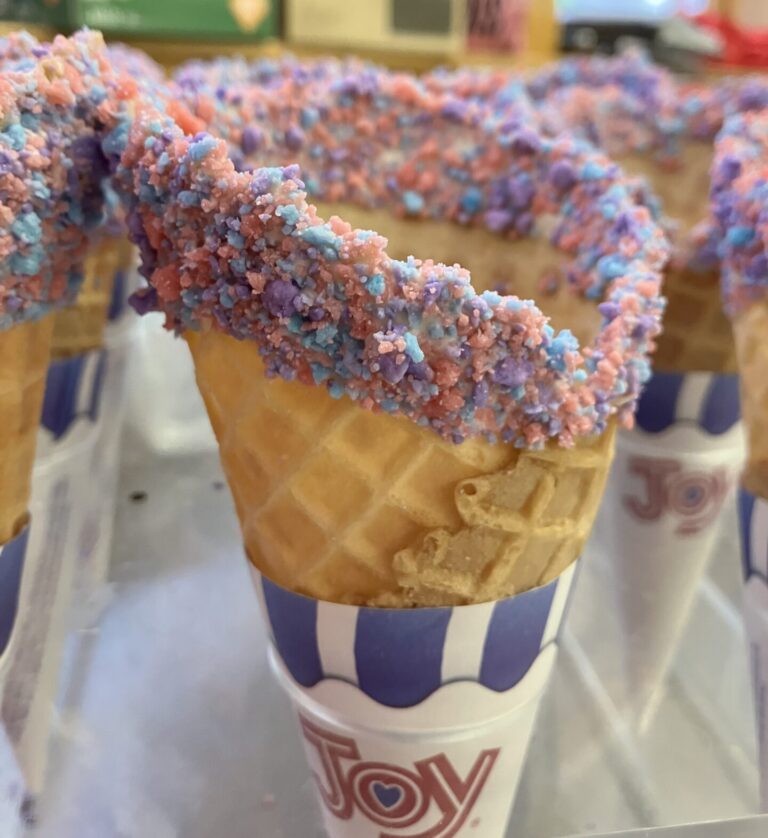 Hand-dipped waffle cone in white chocolate and cotton candy sprinkles